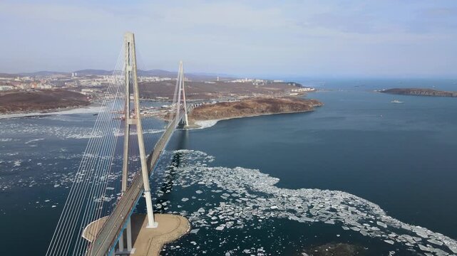 Cable-stayed Russky Bridge in Vladivostok, Russia, connecting Russky Island with the mainland over the Eastern Bosphorus Strait. Winter view with sea partially covered with ice.