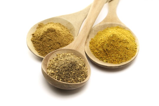 Set shawarma seasoning pile (shoarma), garam masala ground and za'atar spice blend in wooden spoon, isolated on white background, side view