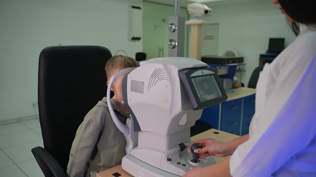 Ophthalmologist checking a boy's vision with an autorefractor