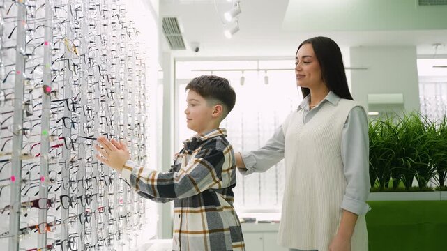Mother and son choosing new eyeglasses at an optical store
