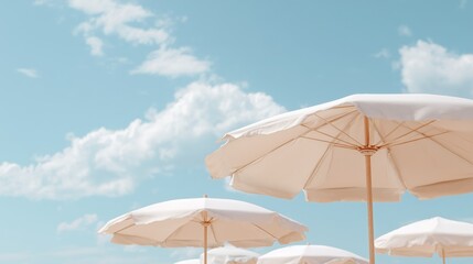 Elegant white beach umbrellas under a bright blue sky with scattered clouds, capturing a serene summer vacation vibe.