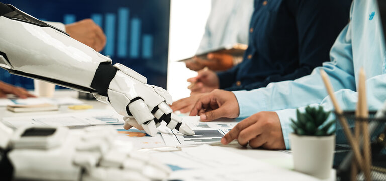A robot and human team collaborate in a modern office setting, analyzing data and charts for strategic decision-making, showcasing the future of work.Noogenesis