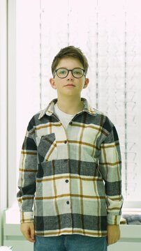 Young boy trying on new glasses at the optical store