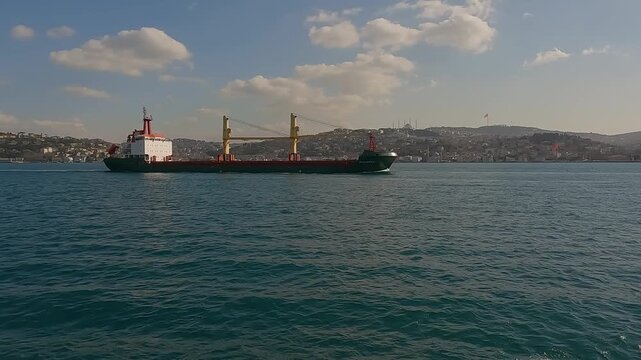 Cargo ship tanker in Bosphorus Strait about to pass under Bosphorus bridge. Istanbul Turkey. Shipping on the bosphorus. A large cargo ship sails along the coast at sea. Sea freight transportation