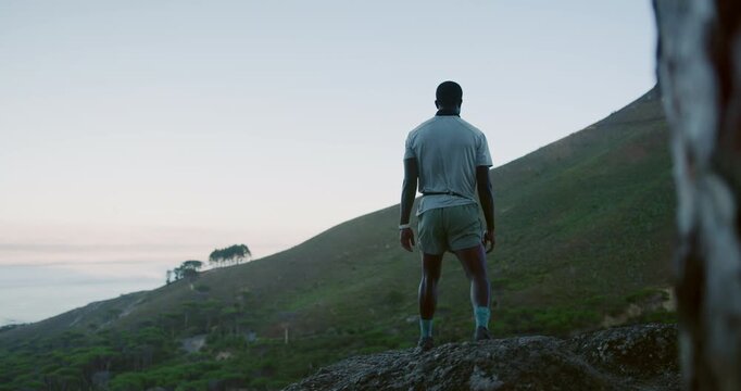 Black man, fitness and conquer with mountain for hiking achievement, success or outdoor journey. Back view, male person or hiker with opens arms for done, trekking or accomplishment on cliff or space