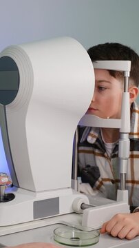 Young boy undergoing eye exam with autorefractor keratometer