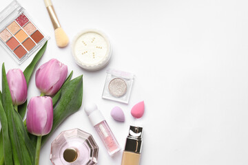 Fototapeta premium Spring composition with different makeup products, perfume and pink tulips on white background, flat lay. Space for text