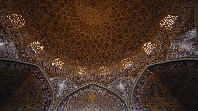 Low angle view of the dome of Sheikh Lotfollah Mosque in Isfahan, Iran, showing detailed Persian tile patterns and Islamic architecture. Famous historic mosque located on Naqsh e Jahan Square