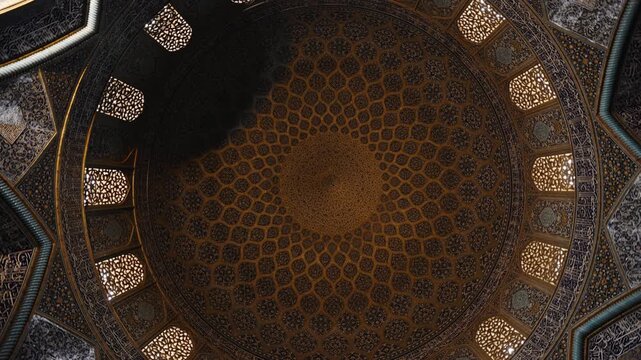 Low angle view of the dome of Sheikh Lotfollah Mosque in Isfahan, Iran, showing detailed Persian tile patterns and Islamic architecture. Famous historic mosque located on Naqsh e Jahan Square