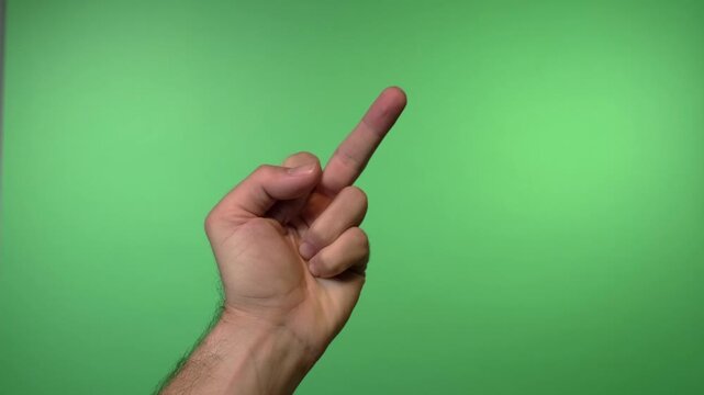 Close up video of a hand giving the middle finger gesture against a solid green background for compositing.