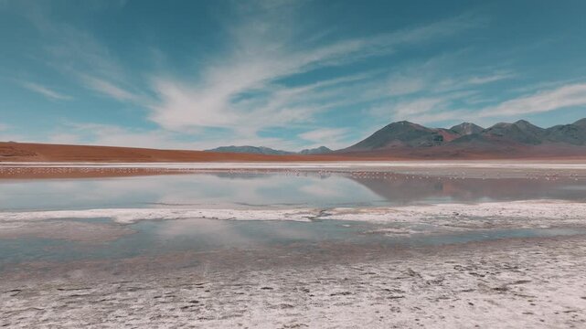 Aerial view of a salt lake in the Bolivian Altiplano, with pale mineral water and reflective surface. Minimalist landscape with soft tones and remote atmosphere.