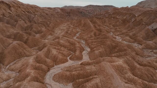 Drone view of rugged desert mountains and dry valleys in northern Chile. Erosion has sculpted dramatic patterns across the arid landscape.