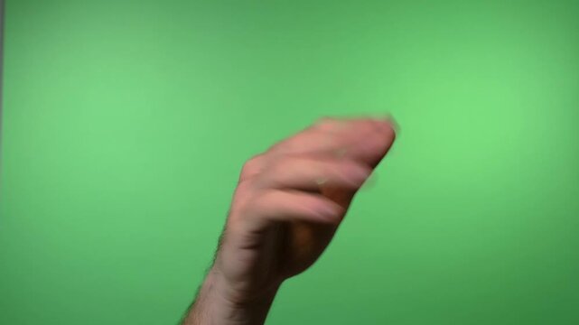 Close up video of a hand making the "go away" shooing gesture against a solid green background for compositing.