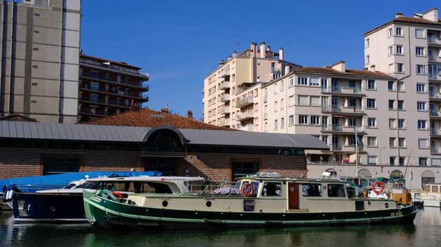Long vintage boat docked urban canal sunny day