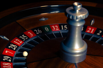 Refined wooden roulette wheel with lucky seven winning pocket in a classic casino environment, illustrating gambling, risk and chance