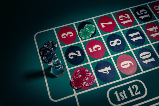 Poker chips and dolly on a roulette table in a casino setting, illustrating gambling, risk, chance and themes related to addiction and dangerous betting behavior