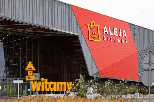Wroclaw, Poland- October 25, 2025: Modern facade of Aleja Bielany shopping mall with large red logo sign and glass entrance under cloudy sky for retail business and consumer lifestyle