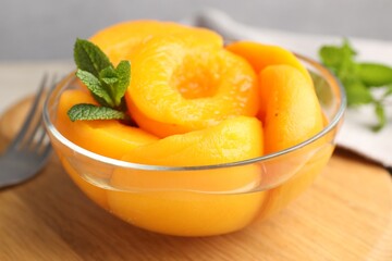 Pickled peaches and mint leaves in bowl on table, closeup © New Africa