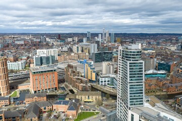 Naklejka premium Aerial drone view across southern Leeds city centre showing railway lines residential towers offices roads and dense urban architecture in West Yorkshire England