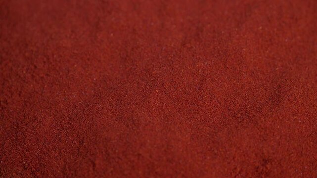 Rustcolored spice macro image, Bright red paprika spice captured in macro on rustic surface, Closeup of vibrant rusty paprika powder texture on aged wooden background