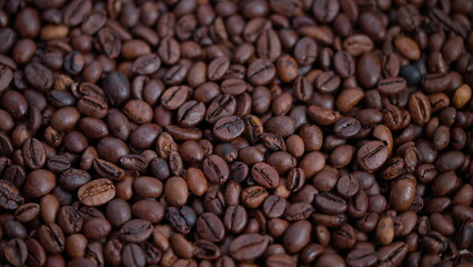 Fototapeta premium Closeup of roasted coffee beans, Macro shot showing glossy dark brown beans, Detailed view of oily roasted coffee beans highlighting rich texture and sheen for marketing