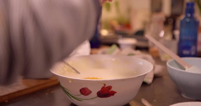 Preparing Delicious Mixture in a Bowl: A person is making a delicious mixtures in a ceramic bowl. capture the moment of preparing and mixing ingredients for creating meal, the moment shows the care.