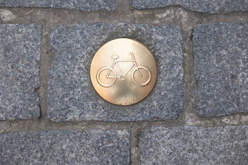 Obraz premium Bicycle path marker on old bruges cobblestone street