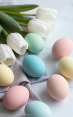 Pastel eggs and white tulips on marble soft spring Easter scene.