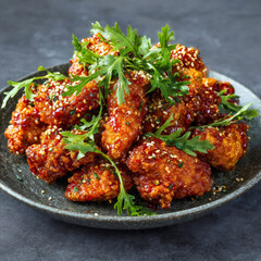 Korean fried chicken with spicy sauce and sesame seeds