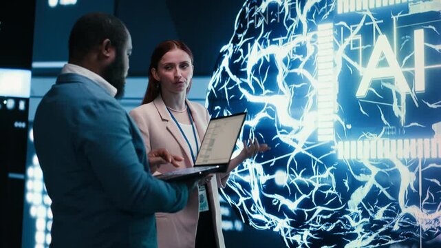 Team of engineers monitors progress of artificial intelligence neural network evolution using laptop. Teamworking colleagues observing rapid development of AI machine learning tech, camera B