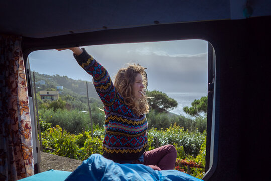 Nerano, Campania, Italy: Vanlife Woman sitting in van looking out at coastal landscape