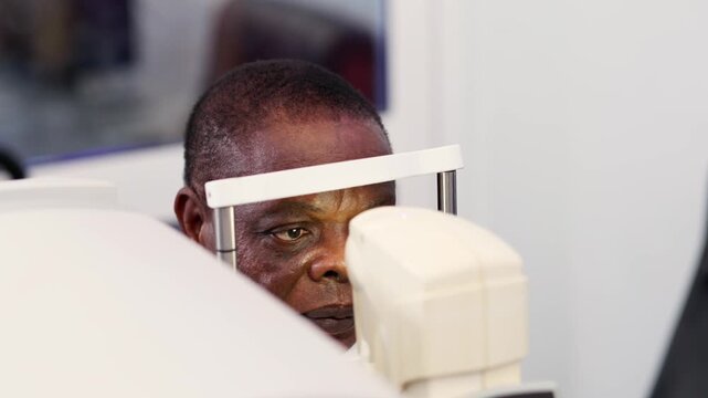 African patient receiving eye examination with a non-contact tonometer (NCT) equipment for vision health