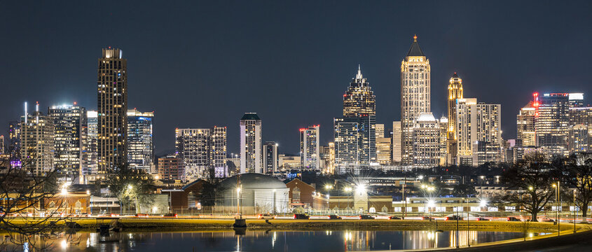 View of the Downtown and Midtown Atlanta Skyline Cityscape showing several prominent buildings, highways, cars, and hotels on a beautiful clear night.