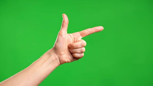 human hand making a finger gun gesture or pointing forward isolated on a green screen background for chromakey compositing representing choice direction goal and aggression