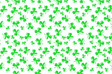 A vibrant green shamrock pattern featuring various sizes of three-leaf clovers scattered randomly across a clean white background, creating a festive and lucky design perfect for Irish celebrations.