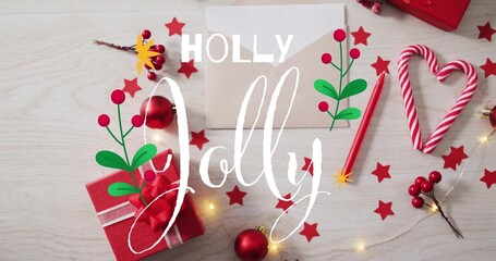 Displaying 'Holly Jolly' over red gift box on wood tabletop with candy cane heart, baubles, lights © vectorfusionart