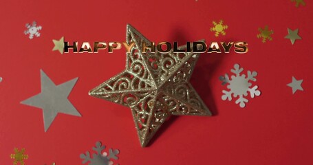 Displaying gold filigree star sparkling on red tabletop with HAPPY HOLIDAYS lettering