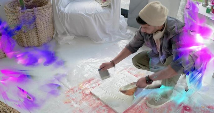 Artist scooping putty scraping art canvas hiding pink rim while purple or blue overlays obscuring wo
