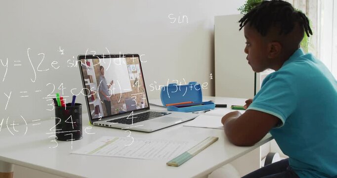 Student writing worksheet while laptop tutor gesturing, math overlays appearing guiding learning