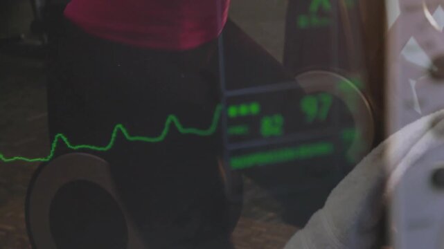 Woman pedaling and gripping handles in gym, causing green monitor waveform 97 tracking heart rate