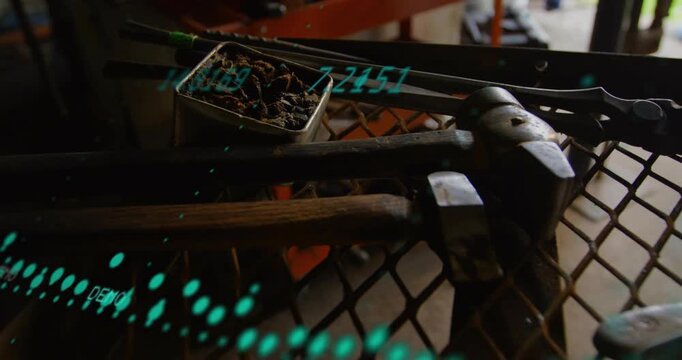 Tools resting on mesh table in workshop, teal overlay starting near tin scanning tools for audit