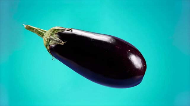 A glossy dark purple eggplant with a green stem rotates in mid-air against a bright blue backdrop. This clean 3D motion graphics asset highlights the smooth texture and color of the vegetable for heal