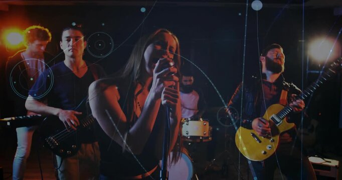 Diverse band playing onstage, spotlights cueing singer singing into vintage mic, graphics peaking