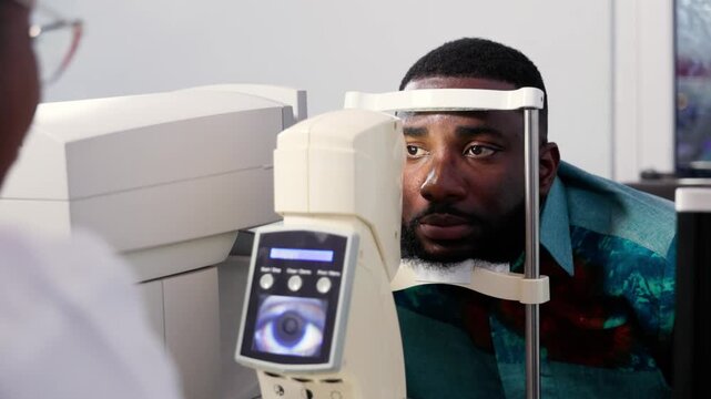 African female optometrist performing an eye exam for a male patient using a non-contact tonometer (NCT)