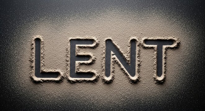 The word 'Lent' written in sand on a dark background.
