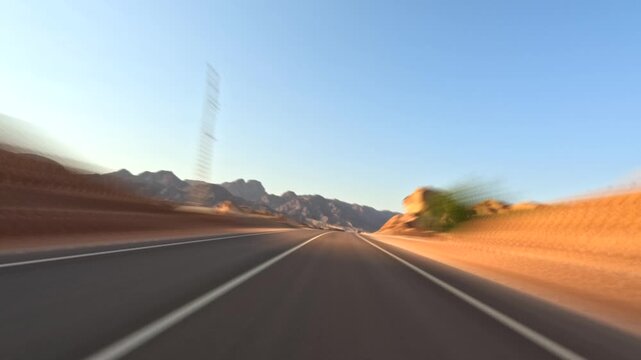 Time lapse of car driving on asphalt road in the desert at sunset