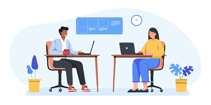 Two colleagues collaborate on laptops in a modern office workspace