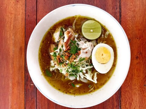Indonesian Bakso Meatball Noodle Soup in White Bowl on Wooden Table
