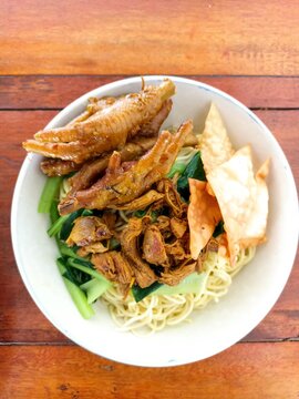 Indonesian Bakso Meatball Noodle Soup in White Bowl on Wooden Table