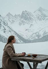 Fototapeta premium Woman in coat enjoying hot drink at wooden table, snowy landscape, winter solitude, mountain vista, serene contemplation.